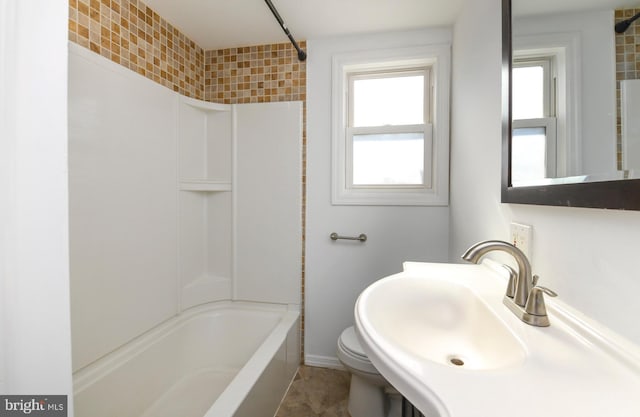 bathroom with toilet, a sink, and tub / shower combination