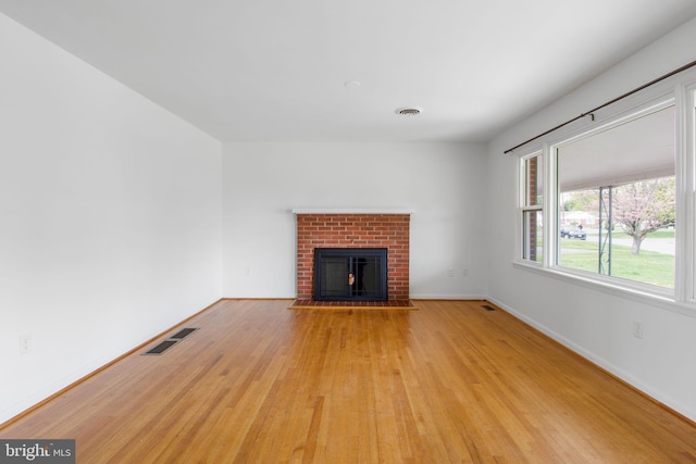 7906 Longmeadow Dr, Frederick, MD 21701 - unfurnished living room featuring baseboards, wood finished floors, visible vents, and a fireplace