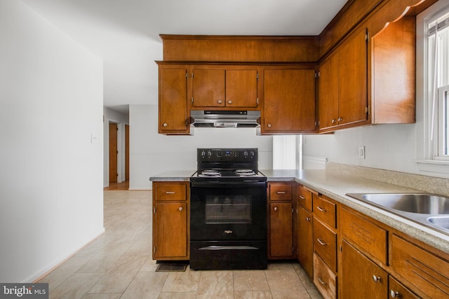 7906 Longmeadow Dr, Frederick, MD 21701 - kitchen with black range with electric cooktop, baseboards, brown cabinets, light countertops, and under cabinet range hood
