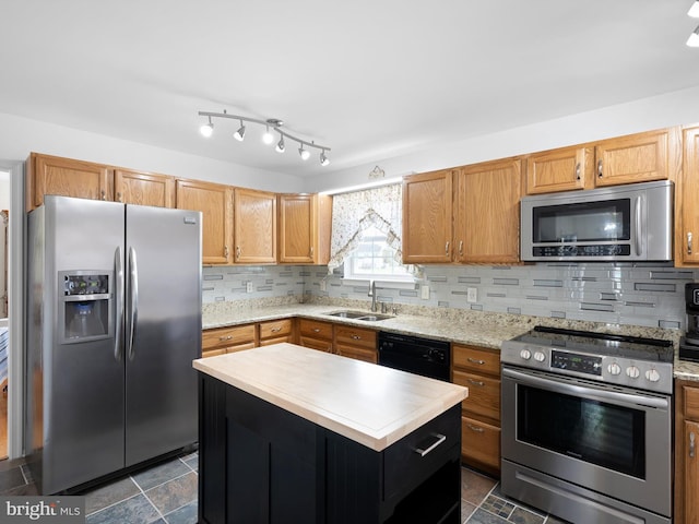 kitchen with a center island, a sink, light countertops, backsplash, and appliances with stainless steel finishes