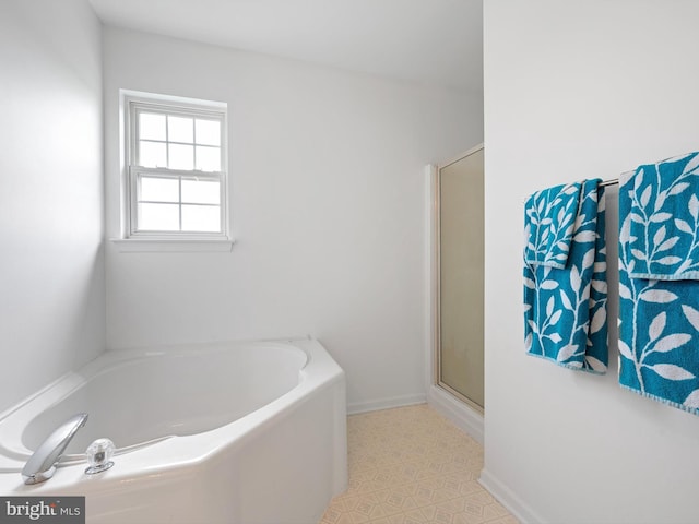 full bathroom with a bath, baseboards, and a shower with shower door