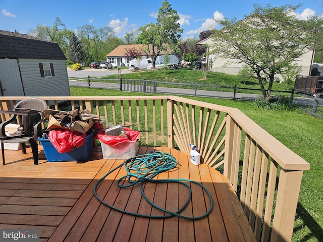wooden deck with a lawn and an outdoor structure