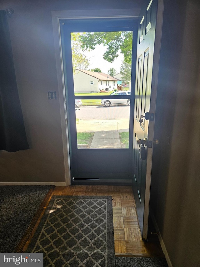 doorway to outside with baseboards