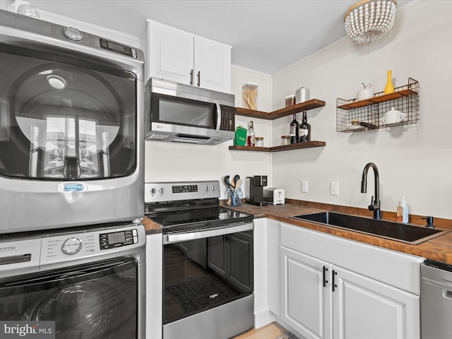 674 94th St Unit 154, Ocean City, MD 21842 - kitchen featuring a sink, white cabinetry, stacked washer / drying machine, wooden counters, and appliances with stainless steel finishes