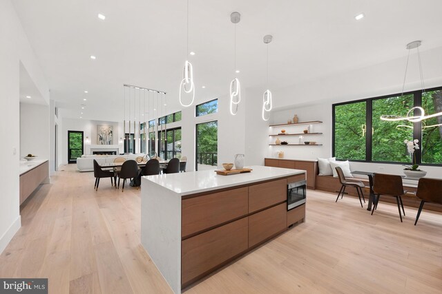 6018 Woodland Ter, Mclean, VA 22101 - kitchen with modern cabinets, stainless steel microwave, open floor plan, light countertops, and light wood-style floors