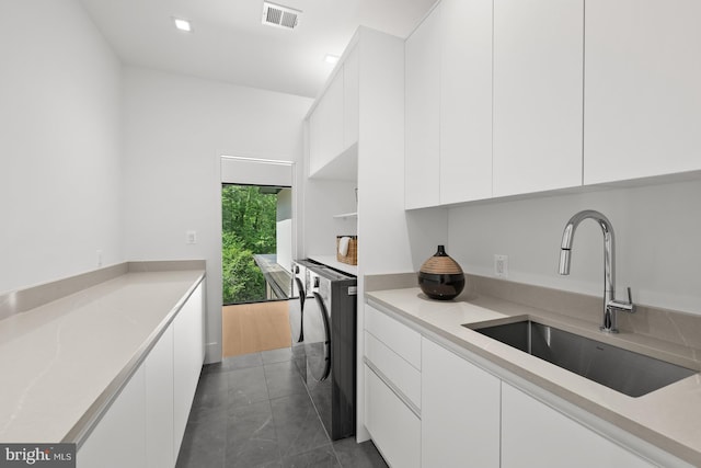 6018 Woodland Ter, Mclean, VA 22101 - kitchen featuring a sink, white cabinets, modern cabinets, washer / clothes dryer, and light countertops