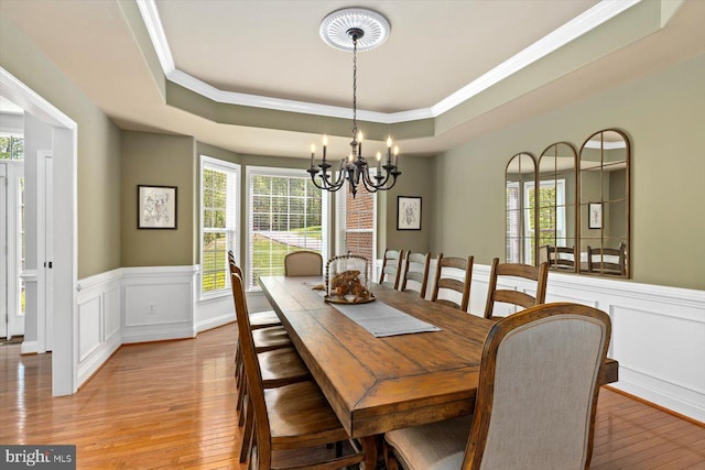 dining space featuring crown molding, a notable chandelier, a healthy amount of sunlight, and light wood-type flooring