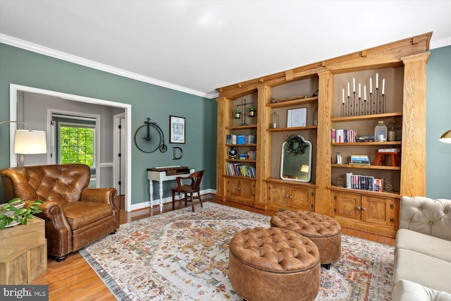 living room with baseboards, ornamental molding, and light wood-type flooring