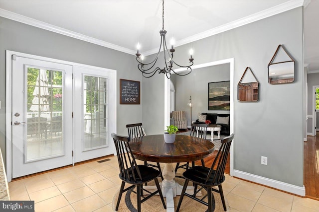 dining room featuring visible vents, baseboards, a chandelier, ornamental molding, and light tile patterned flooring