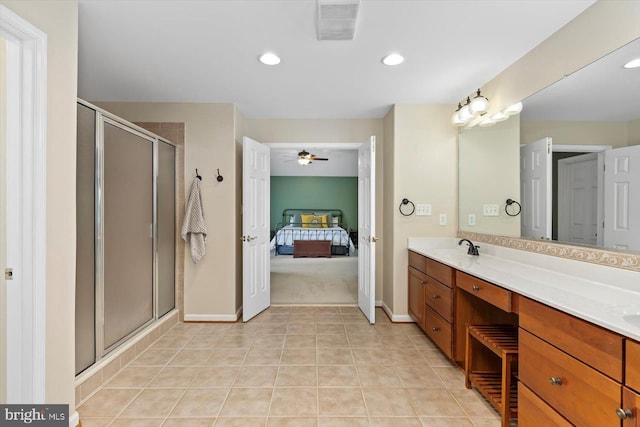 ensuite bathroom with baseboards, visible vents, a shower stall, and a sink