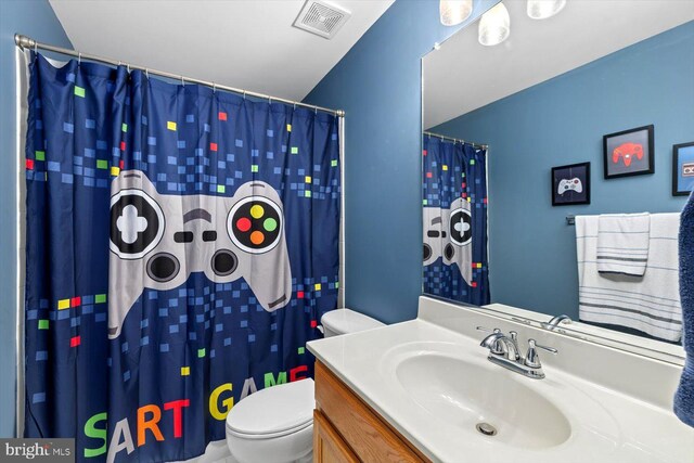 full bathroom featuring visible vents, a shower with curtain, toilet, and vanity