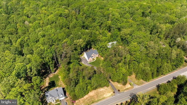 birds eye view of property featuring a wooded view