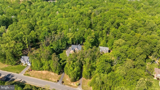 bird's eye view with a wooded view