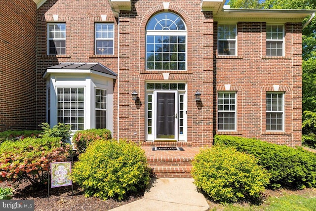 property entrance featuring brick siding