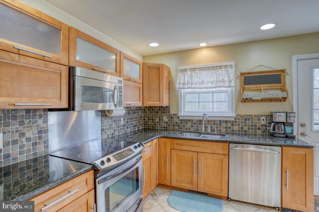 519 Squawigm Rd, Dover, DE 19901 - kitchen with a healthy amount of sunlight, dark stone counters, stainless steel appliances, and a sink