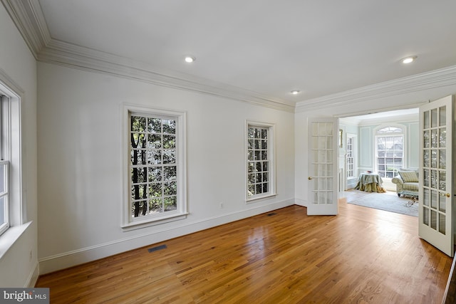 unfurnished room featuring baseboards, ornamental molding, french doors, and wood finished floors