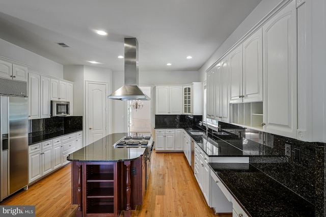 kitchen with open shelves, appliances with stainless steel finishes, a sink, island exhaust hood, and backsplash