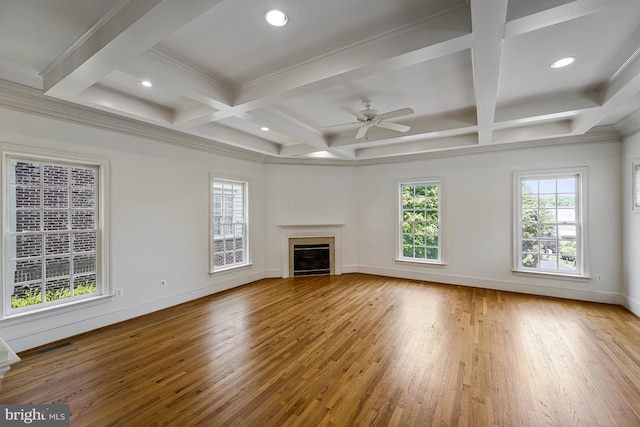 unfurnished living room featuring a glass covered fireplace, beamed ceiling, baseboards, hardwood / wood-style flooring, and coffered ceiling