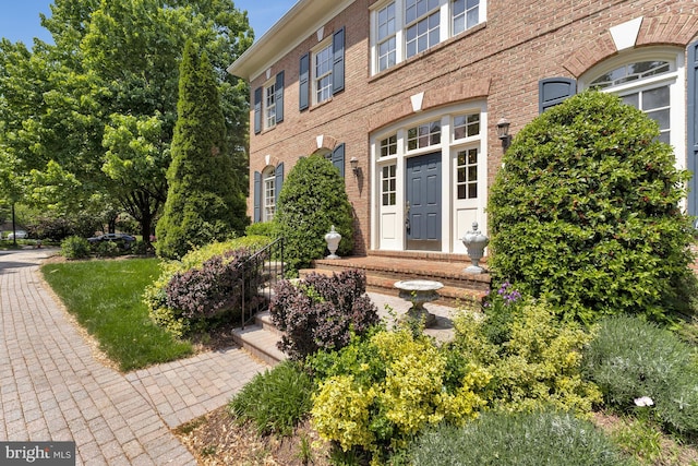view of exterior entry with brick siding