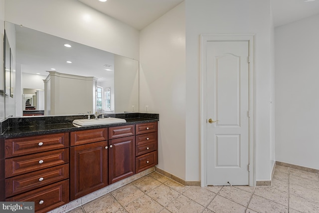bathroom featuring baseboards, vanity, recessed lighting, and stone tile floors