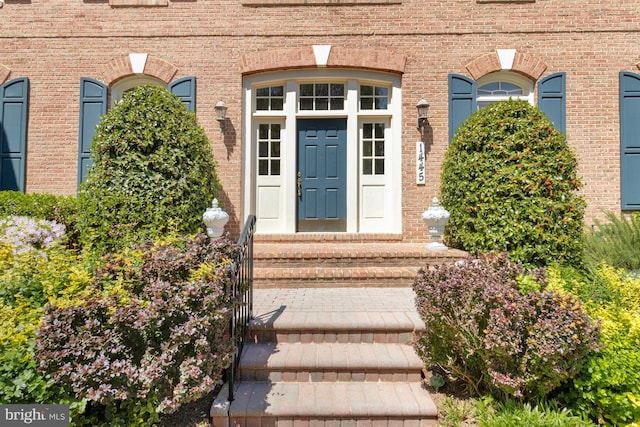 view of exterior entry featuring brick siding