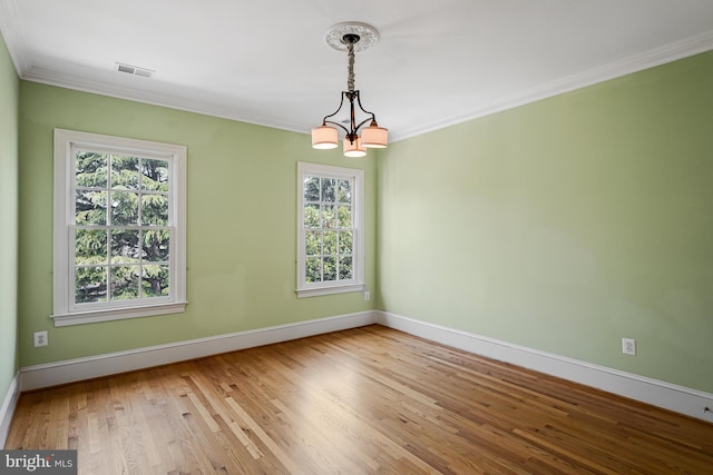empty room featuring baseboards, plenty of natural light, a chandelier, and visible vents