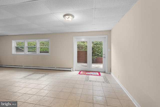 interior space featuring a baseboard radiator, a wealth of natural light, light tile patterned flooring, and a paneled ceiling