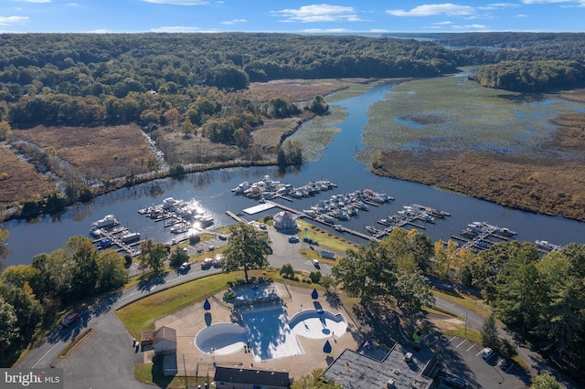 drone / aerial view with a forest view and a water view
