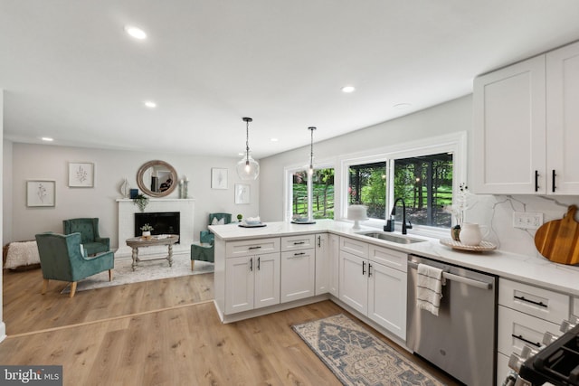 kitchen with appliances with stainless steel finishes, a sink, plenty of natural light, white cabinetry, and recessed lighting
