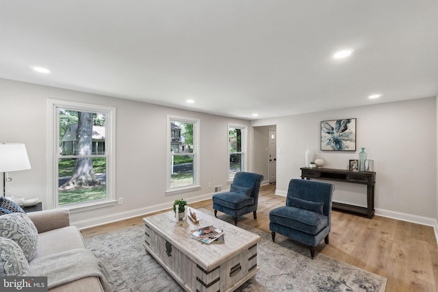 living area with recessed lighting, light wood-style flooring, and baseboards