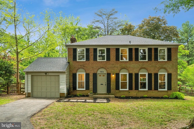 view of front of property featuring a garage, a chimney, asphalt driveway, and brick siding