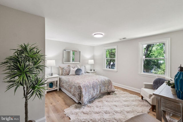 bedroom with light wood finished floors and baseboards