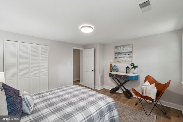 bedroom featuring wood finished floors, baseboards, and a closet