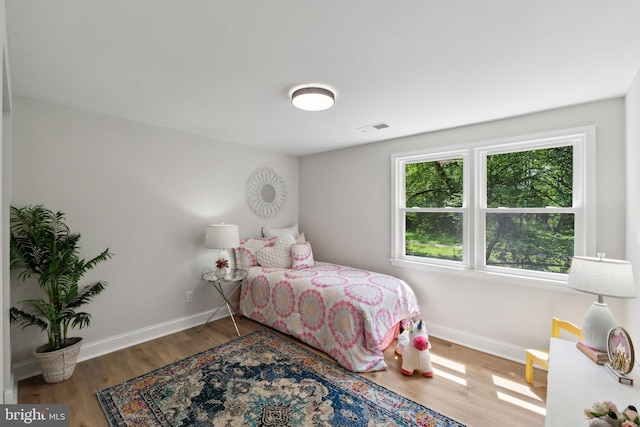 bedroom featuring baseboards and wood finished floors