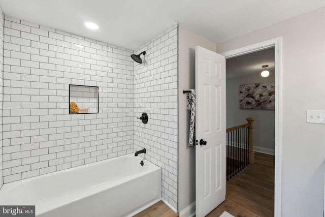bathroom with wood finished floors, bathing tub / shower combination, baseboards, and recessed lighting