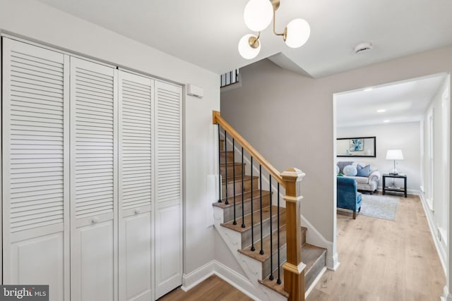 staircase featuring wood finished floors and baseboards
