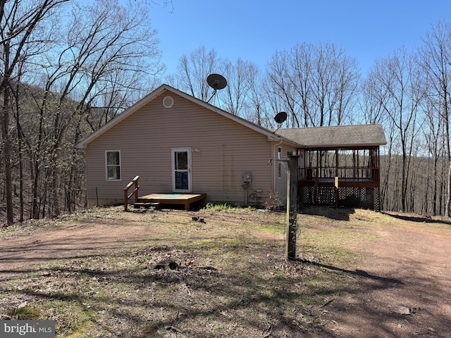 rear view of property with a sunroom and a deck