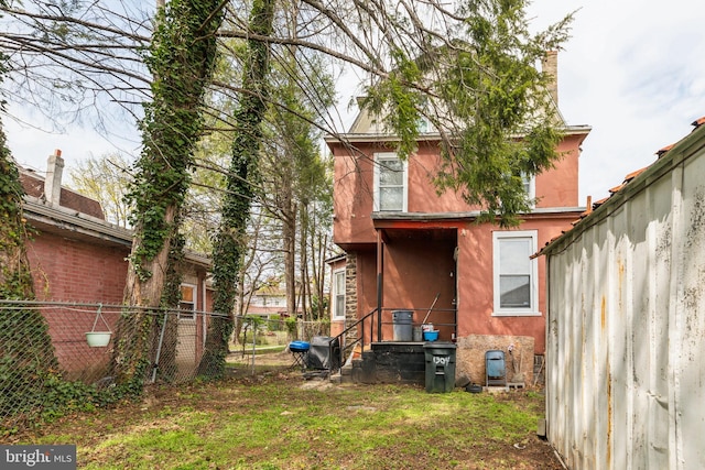 back of house with stucco siding and fence