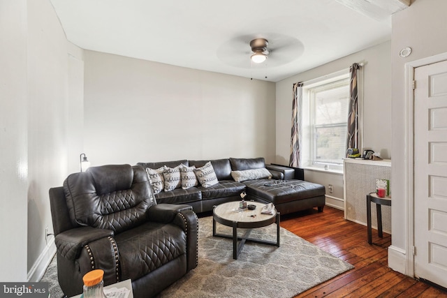 living room with dark wood finished floors, a ceiling fan, and baseboards