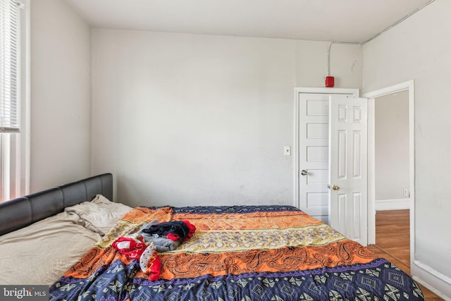 bedroom featuring baseboards and wood finished floors