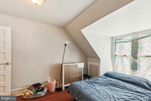 bedroom featuring lofted ceiling and wood finished floors