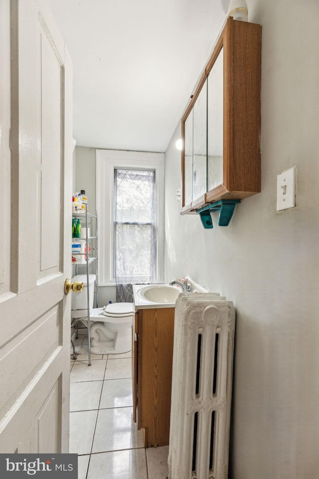 bathroom featuring vanity, radiator, toilet, and tile patterned flooring