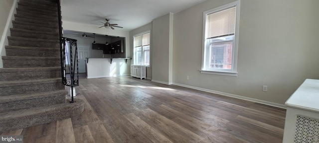 2127 S 63rd St, Philadelphia, PA 19142 - unfurnished living room with radiator, stairs, wood finished floors, and plenty of natural light