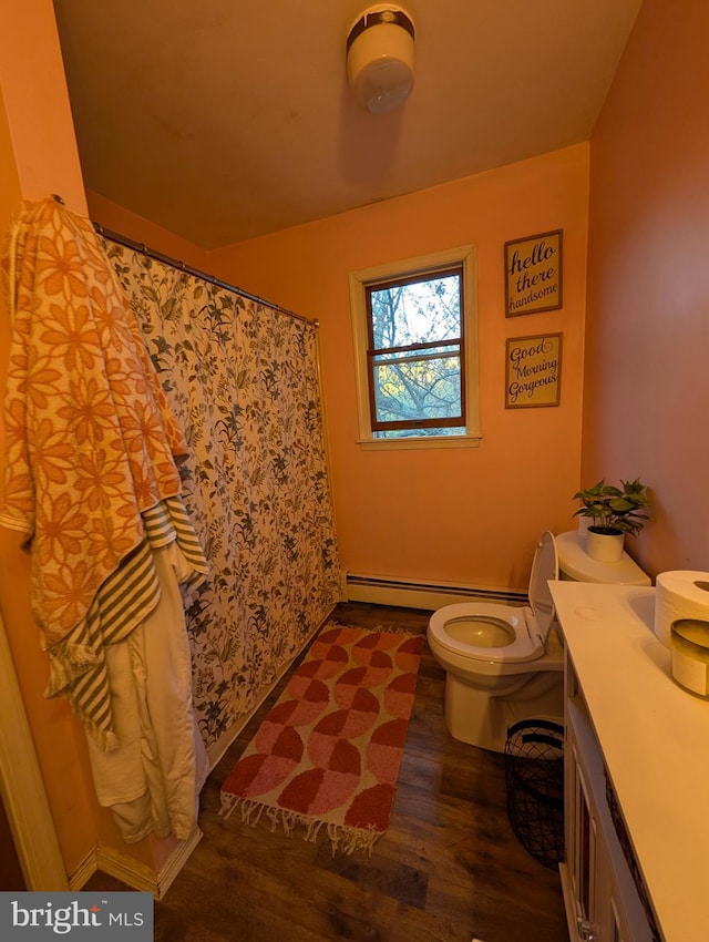 61 Perry Rd, Woodbine, NJ 08270 - full bath with a baseboard heating unit, toilet, wood finished floors, curtained shower, and vanity