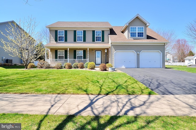 view of front facade with central air condition unit, a front lawn, aphalt driveway, covered porch, and an attached garage