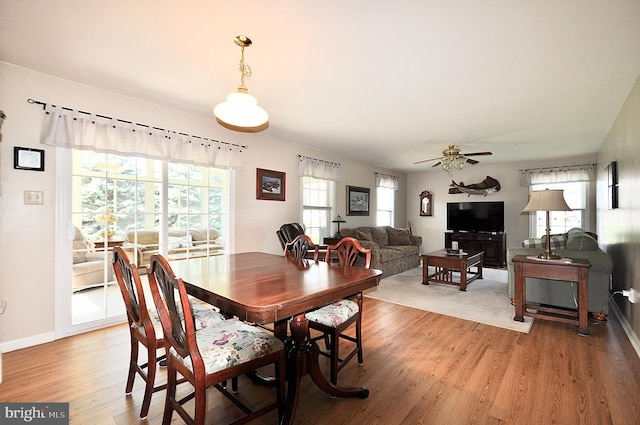 dining room with baseboards, a ceiling fan, and light wood-type flooring