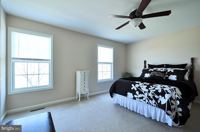 carpeted bedroom with baseboards, visible vents, and ceiling fan
