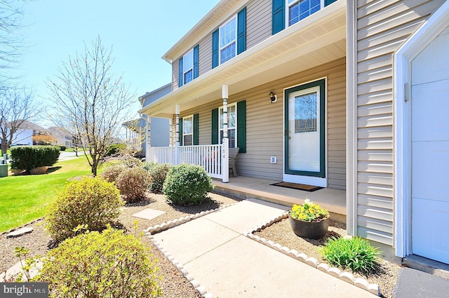 entrance to property with a yard and covered porch