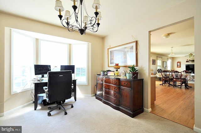 office space featuring baseboards, carpet flooring, a wealth of natural light, and a chandelier