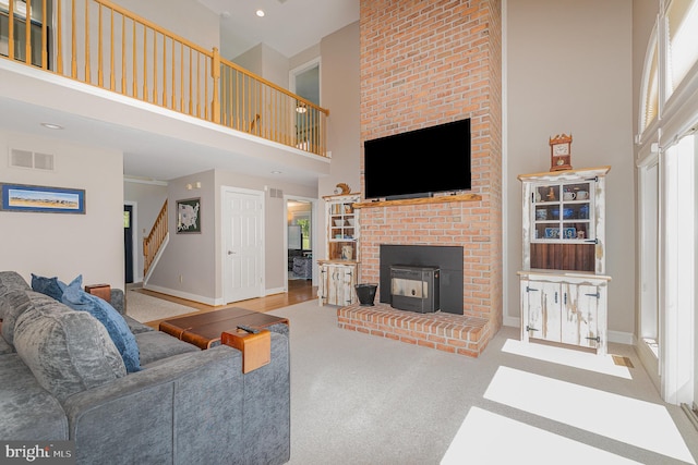 living area with stairway, baseboards, a high ceiling, and visible vents